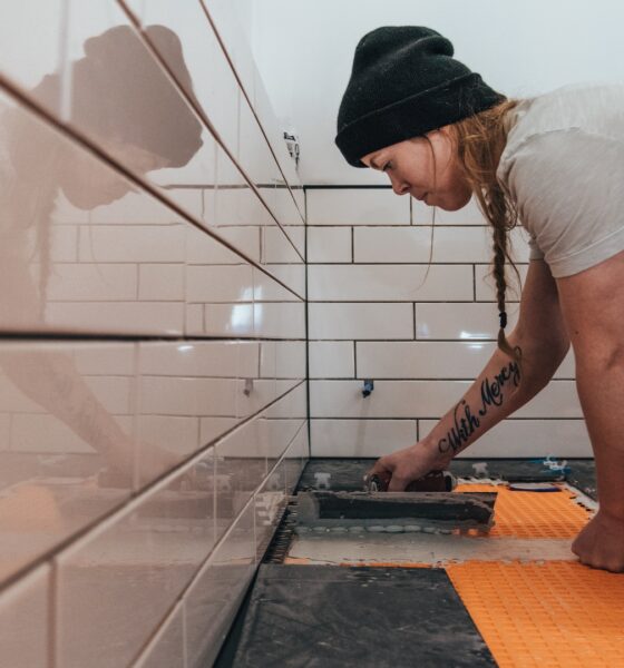 girl putting tiles in white bathroom