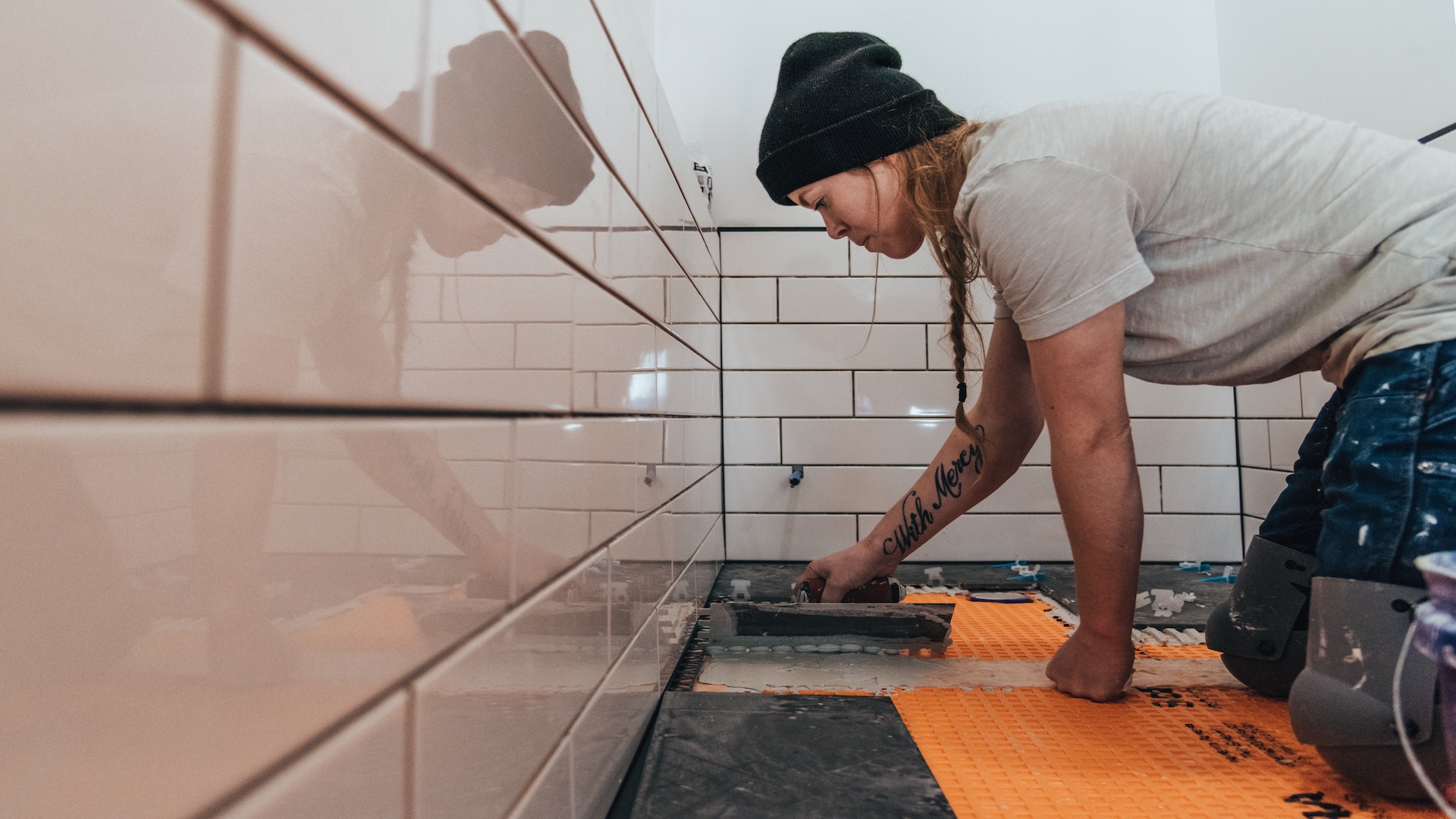girl putting tiles in white bathroom