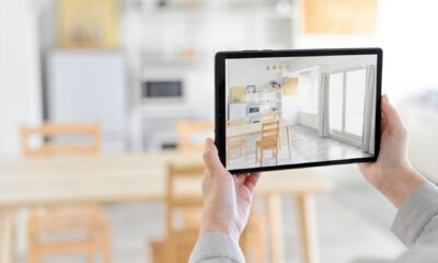 Osoba drži tablet s prikazom svijetle blagovaonice i kuhinje u aplikaciji za uređenje interijera.