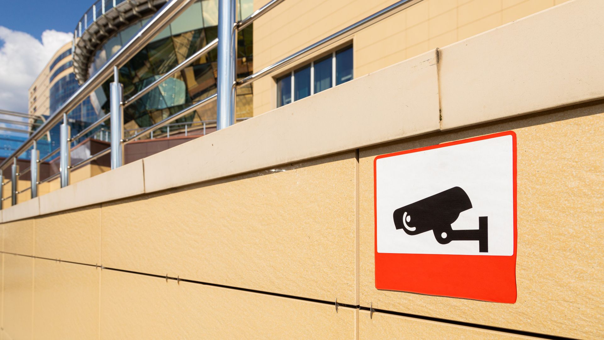 videonadzor javnih površina - znak na smedjem zidu