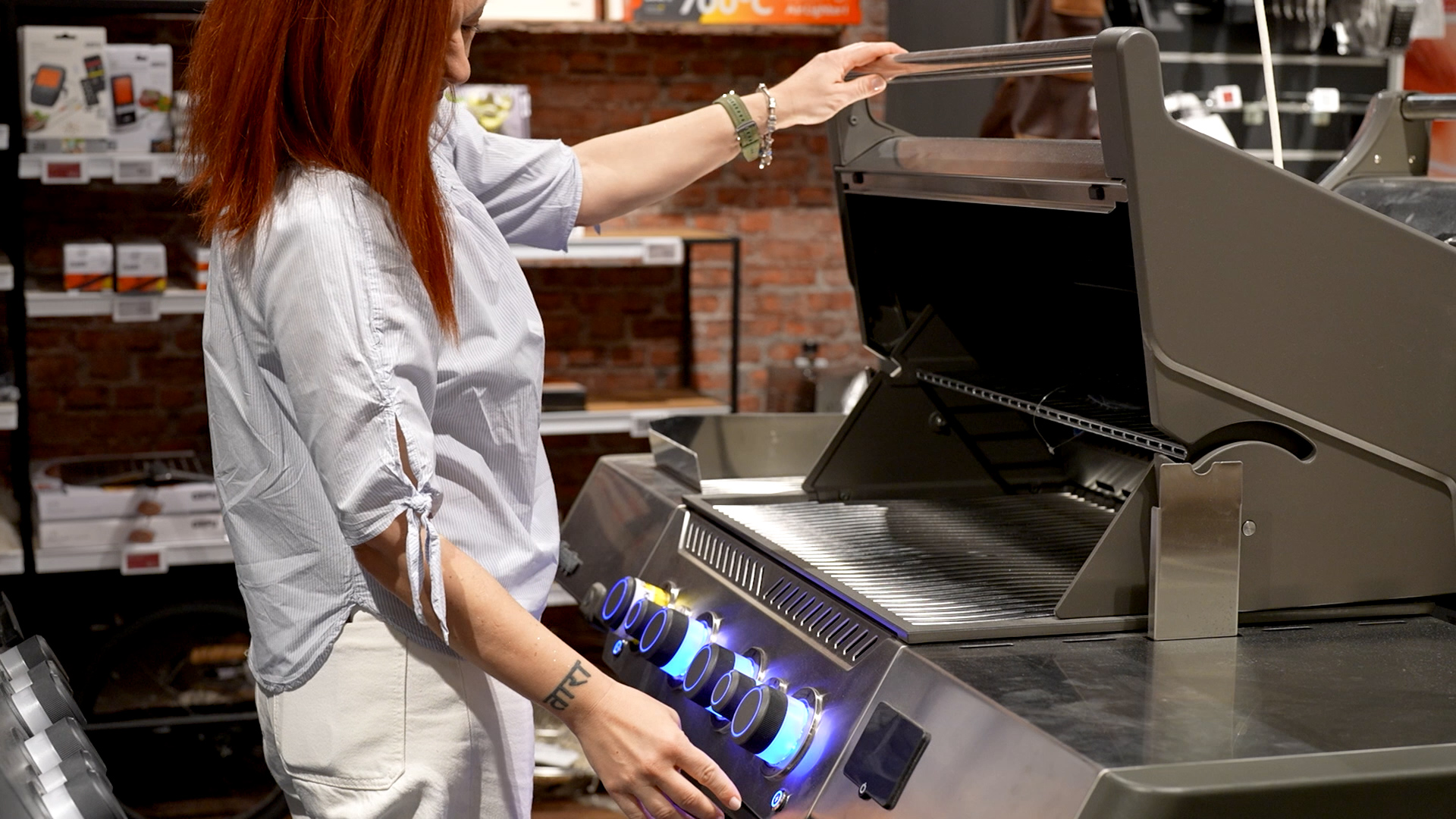 žena koja gleda plinski roštilj i razmišlja koji roštilj odabrati