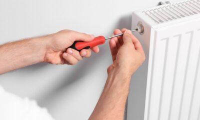 Ruka ključem odzračuje radijator na ventilu za odzračivanje prije početka sezone grijanja